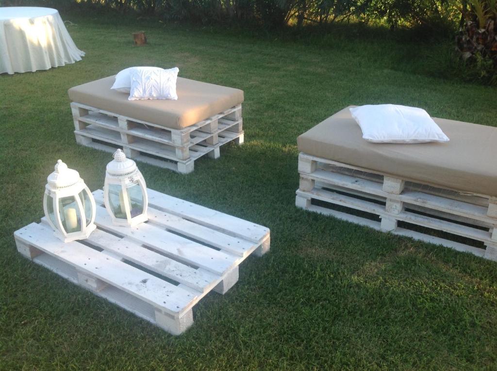two beds sitting on the grass in a yard at Il Vigneto Resort in Menfi