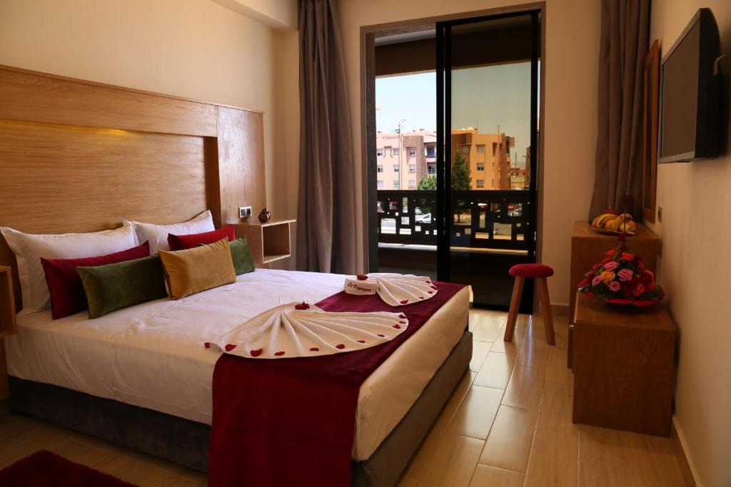 a bedroom with a large bed with a large window at LE VOYAGEUR MARRAKECH in Marrakech