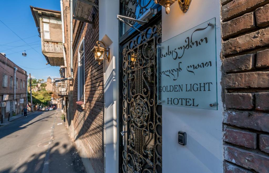 uma placa na lateral de um edifício ao lado de uma rua em Golden Light Hotel em Tbilisi