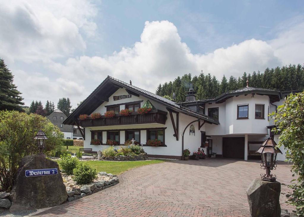 a large white house with a driveway at Ferienwohnung Haus Edelweiss in Winterberg
