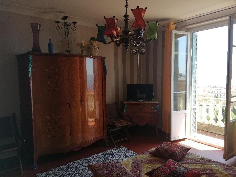 a living room with a dresser and a large window at Villa Cécile in Ajaccio