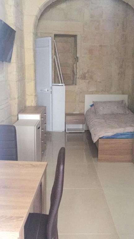- une chambre avec un lit, une table et une chaise dans l'établissement Valletta West Street Studio, à La Valette