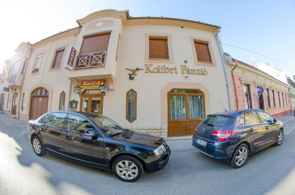 two cars parked in front of a building at Kolibri Panzió in Baja