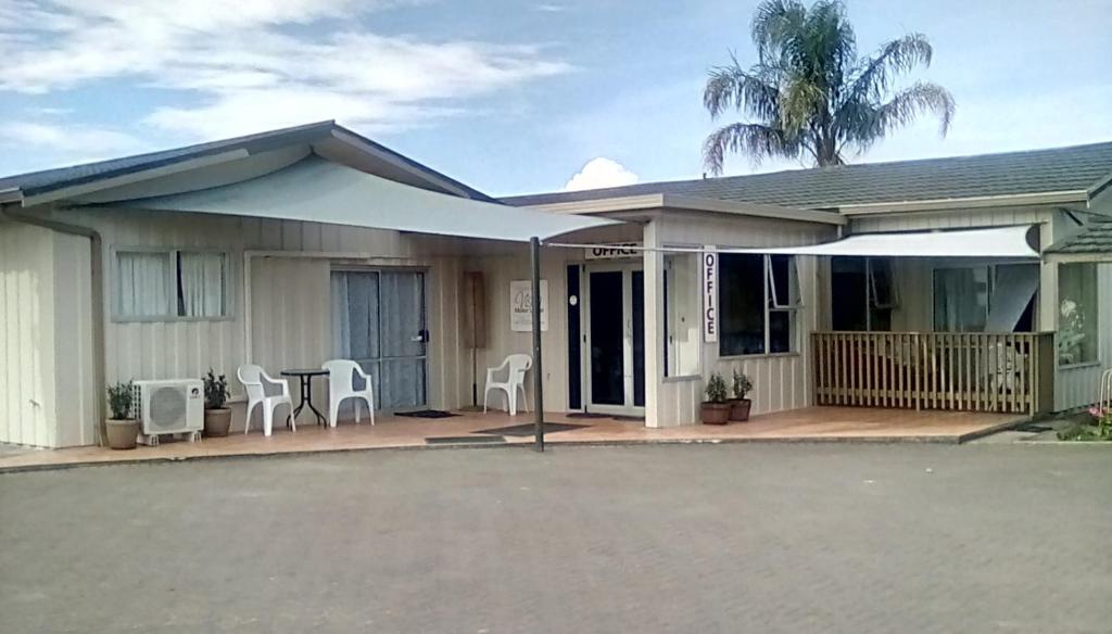 Casa con porche con mesa y sillas en Vista Motor Lodge, en Wairoa