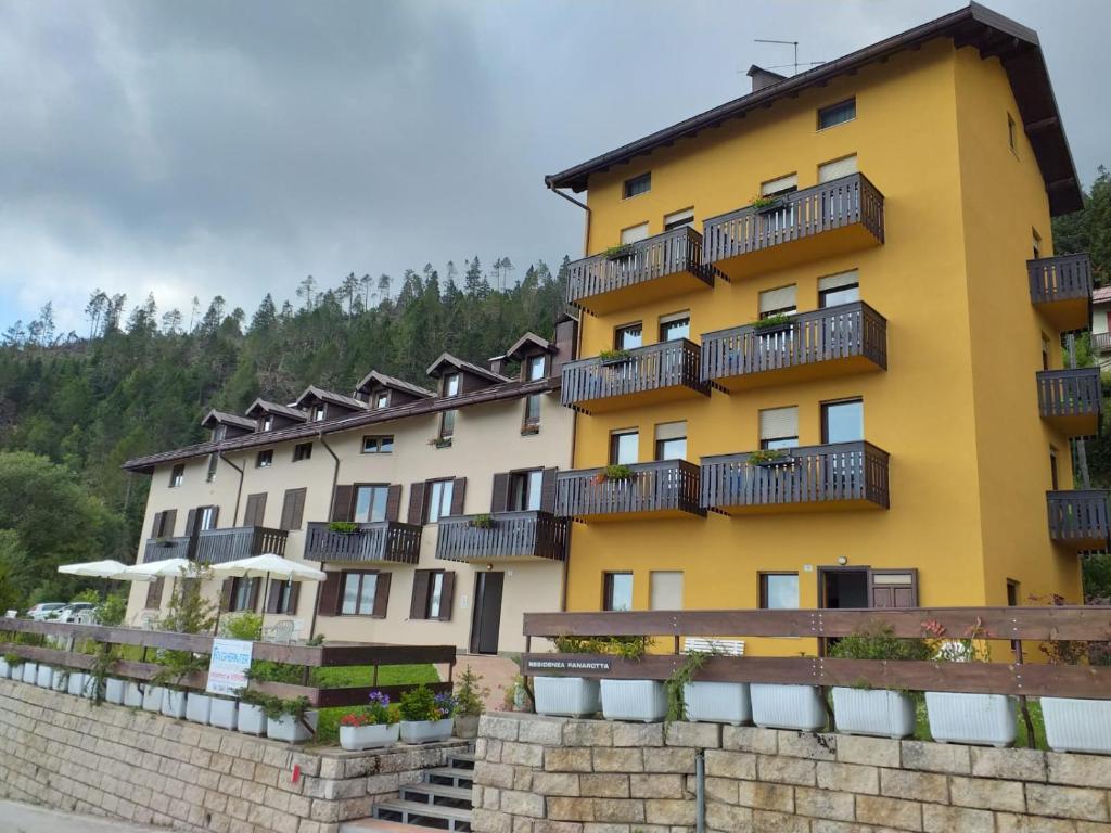 un edificio amarillo con balcones en un lateral en Residenza Panarotta - Vetriolo(1500m), en Levico Terme