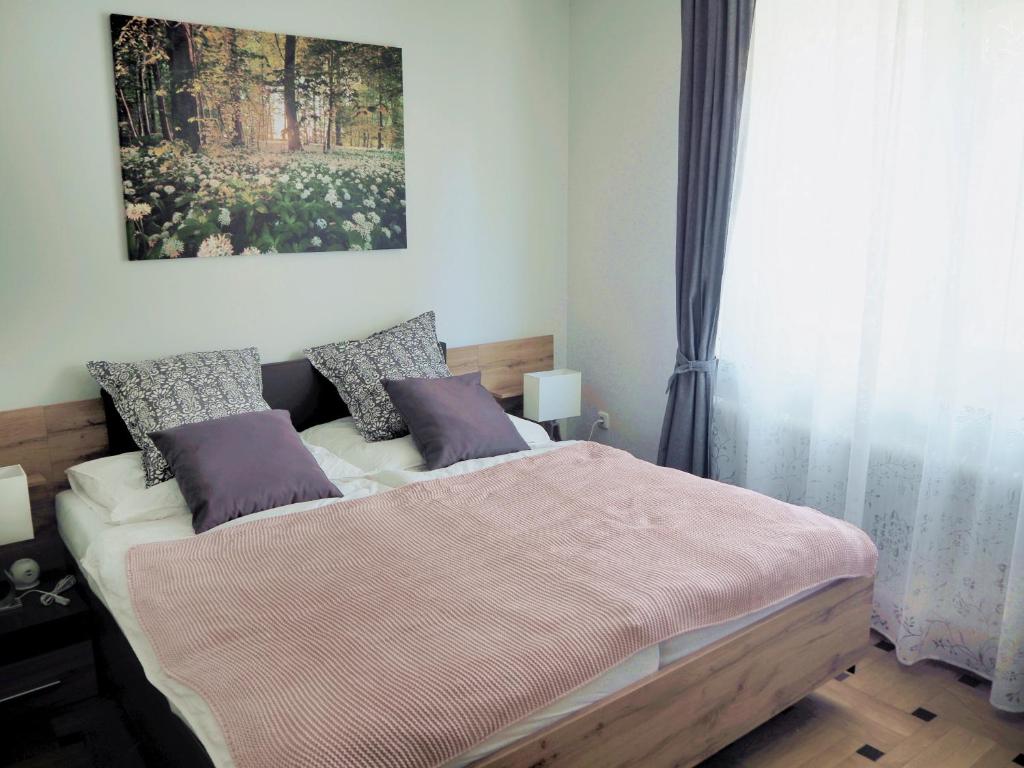 a bedroom with a bed and a painting on the wall at Appartement am Bauernhof "Archehof im Rabnitztal" in Oberrabnitz