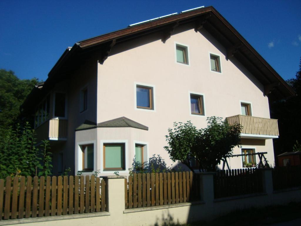 Casa blanca con valla de madera en Ferienwohnungen Klammsteiner, en Lienz