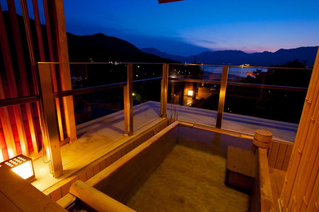 a balcony with a view of the mountains at night at Miyajima Grand Hotel Arimoto in Miyajima