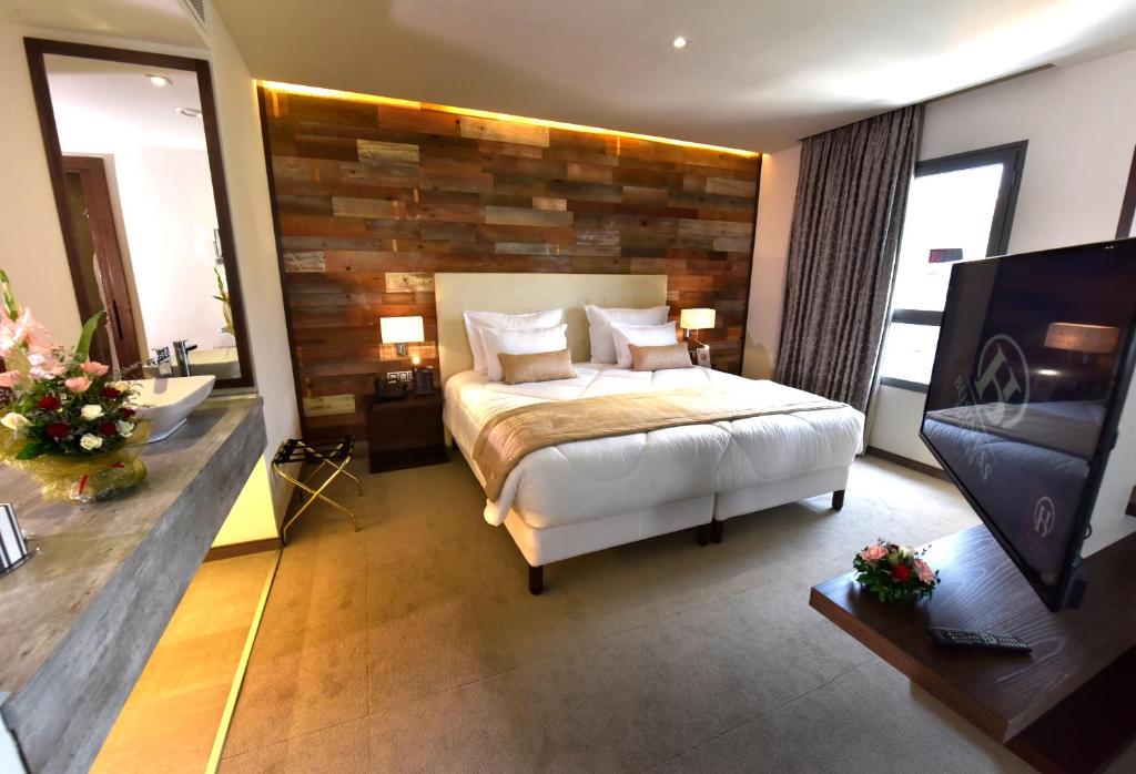 um quarto com uma cama e uma parede de madeira em BUSINESS HOTEL SFAX em Sfax