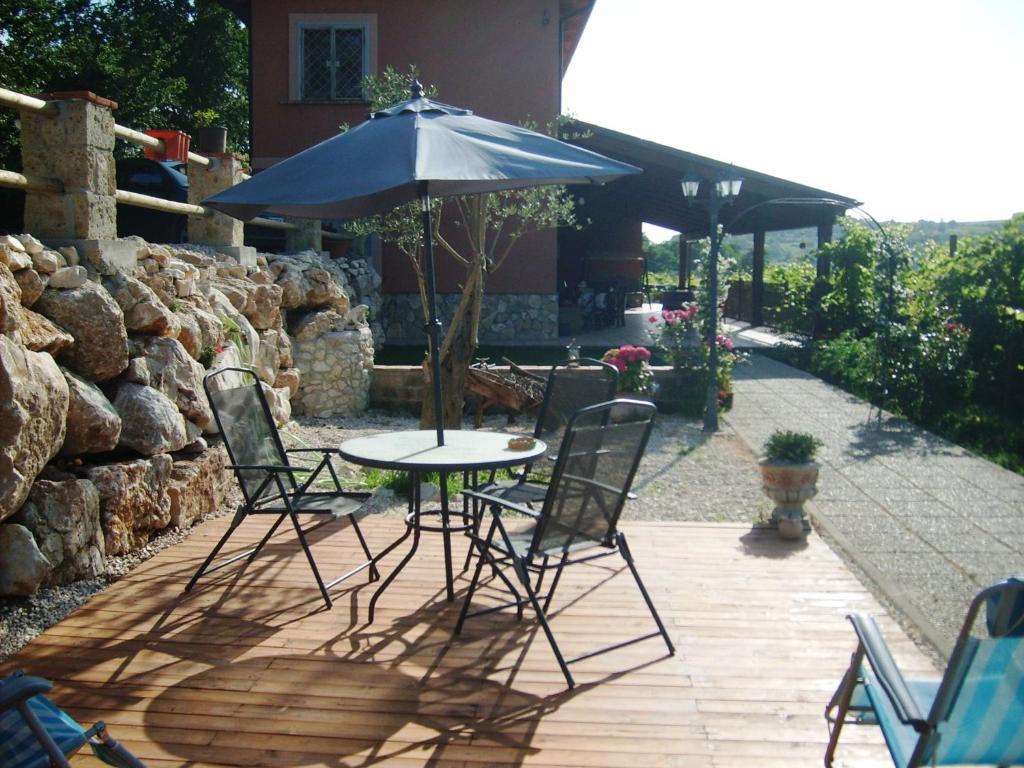 a table and chairs with an umbrella on a patio at Grappoloduva B&B in Solopaca