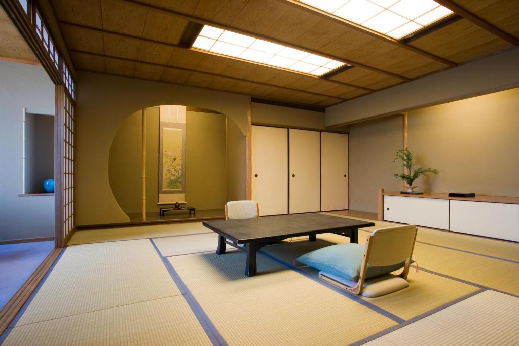 an empty room with a table and chairs at Miyajima Grand Hotel Arimoto in Miyajima