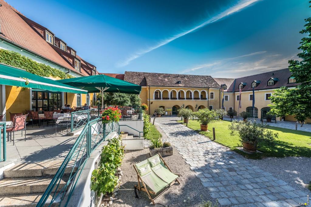 einen Innenhof mit Tischen und Stühlen und ein Gebäude in der Unterkunft Hotel Althof Retz in Retz