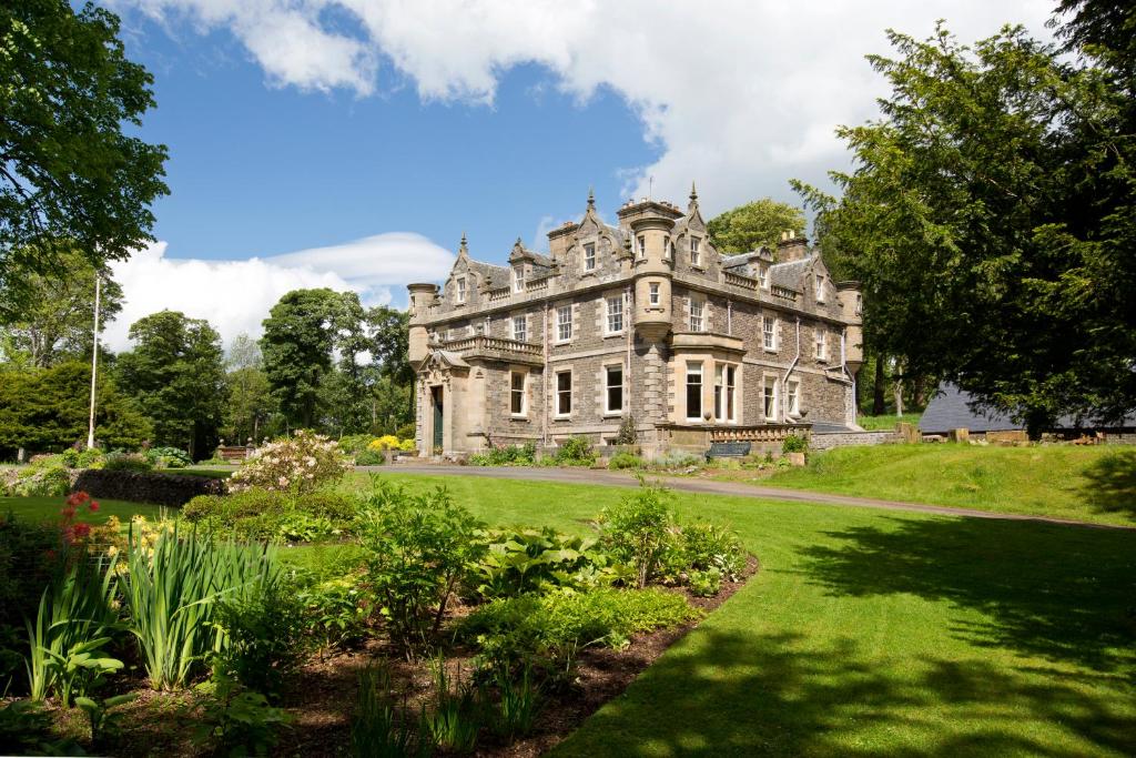 an old castle with a garden in front of it at Crookston House B&B 