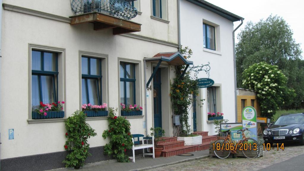 una casa blanca con flores en vidrieras en Hotel Spitzenhoernbucht en Wolgast