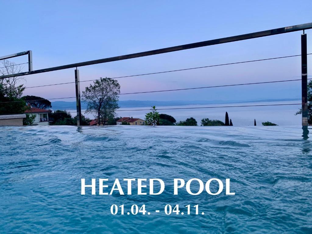 uma imagem de uma piscina aquecida com água em Apartment Pearl of Kvarner Lovran em Lovran