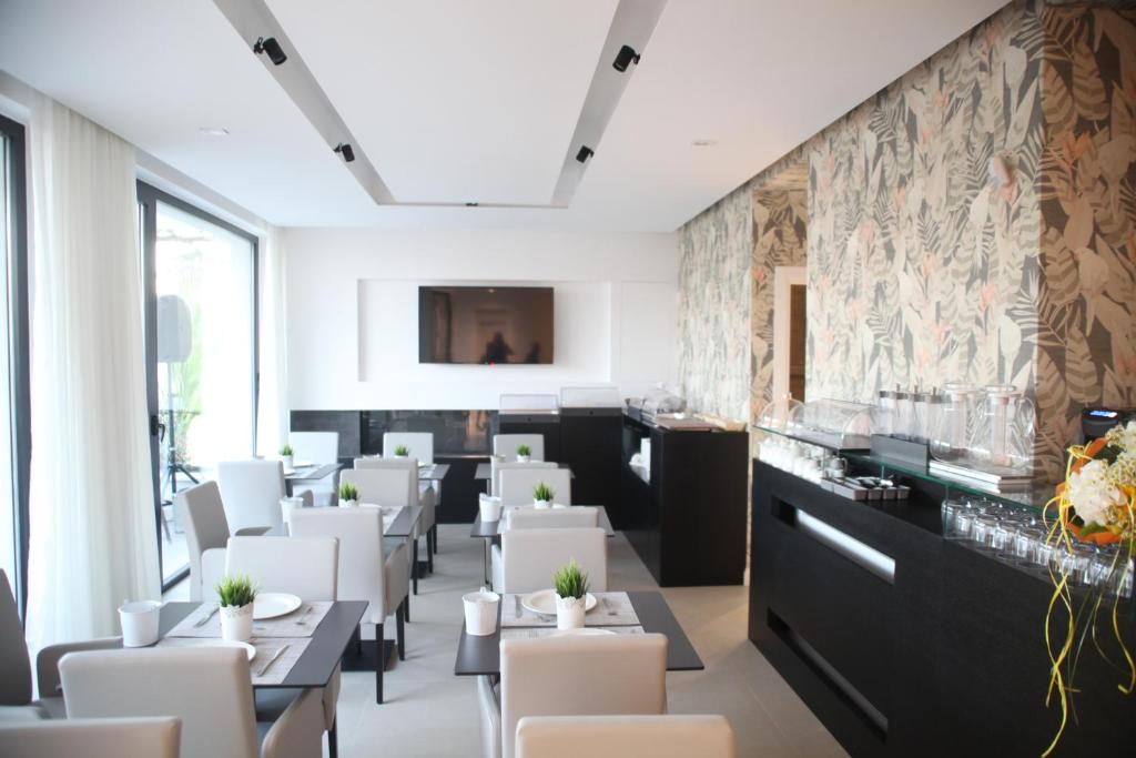 a dining room with tables and white chairs at Villa Pina in Bari