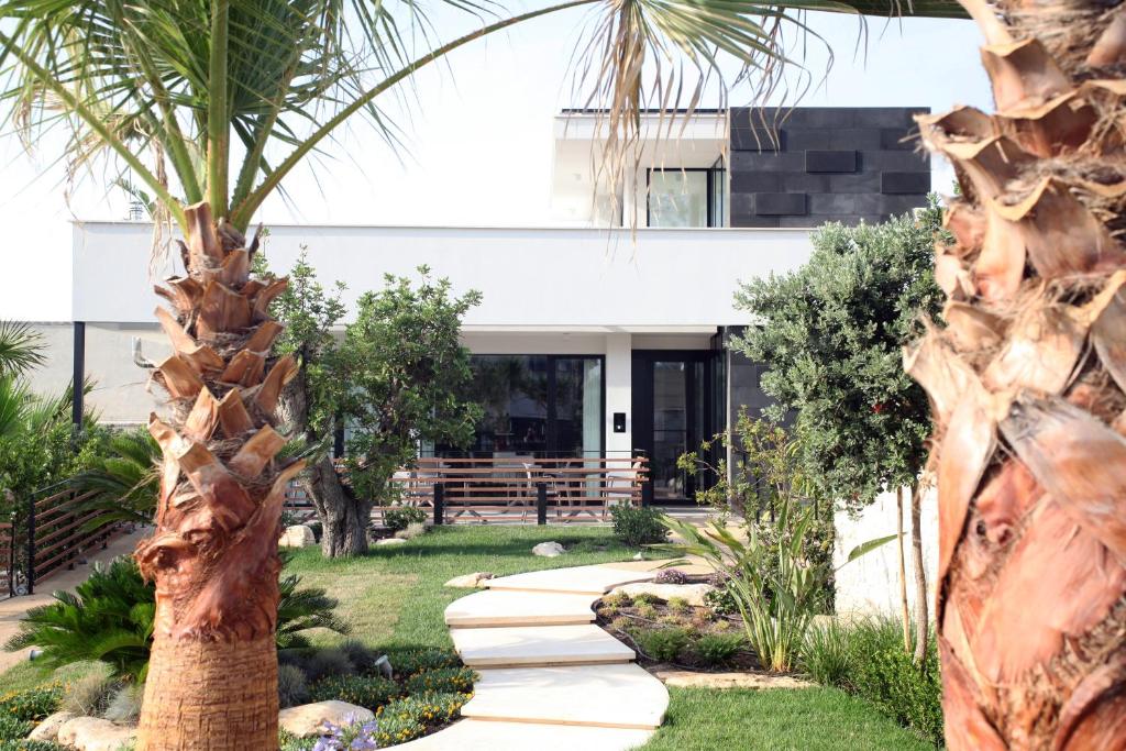 a garden with a palm tree and a walkway at Villa Pina in Bari