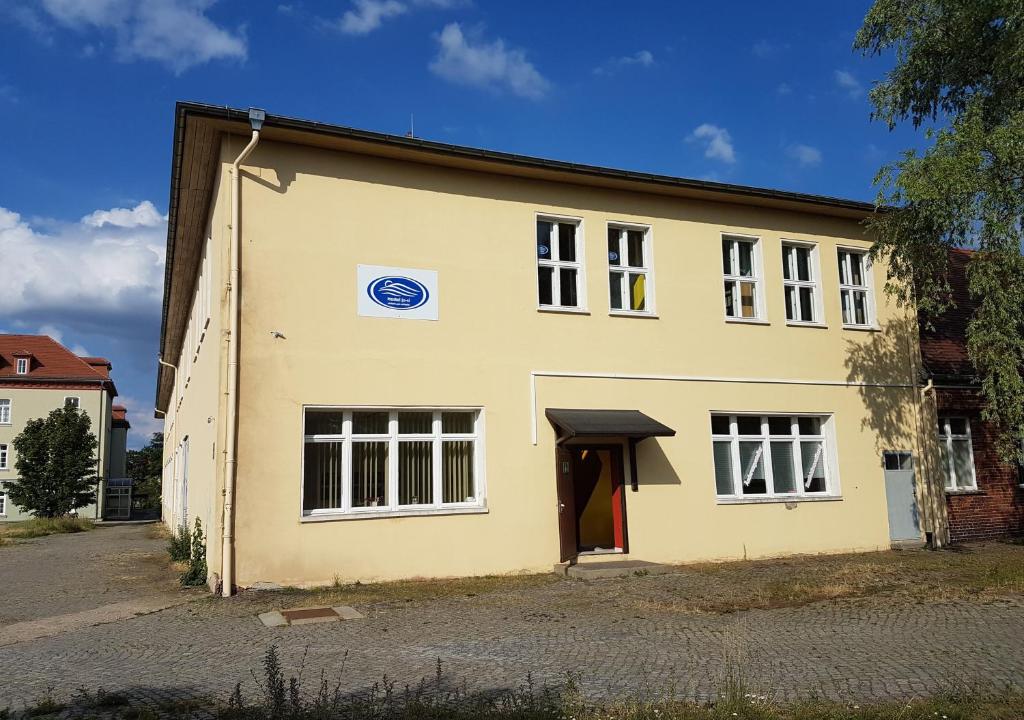 an old yellow building with a red door at Hostel jo-si in Kamenz