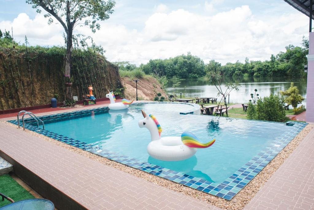a pool with two inflatable swans in the water at Keree Lakeview in Chanthaburi