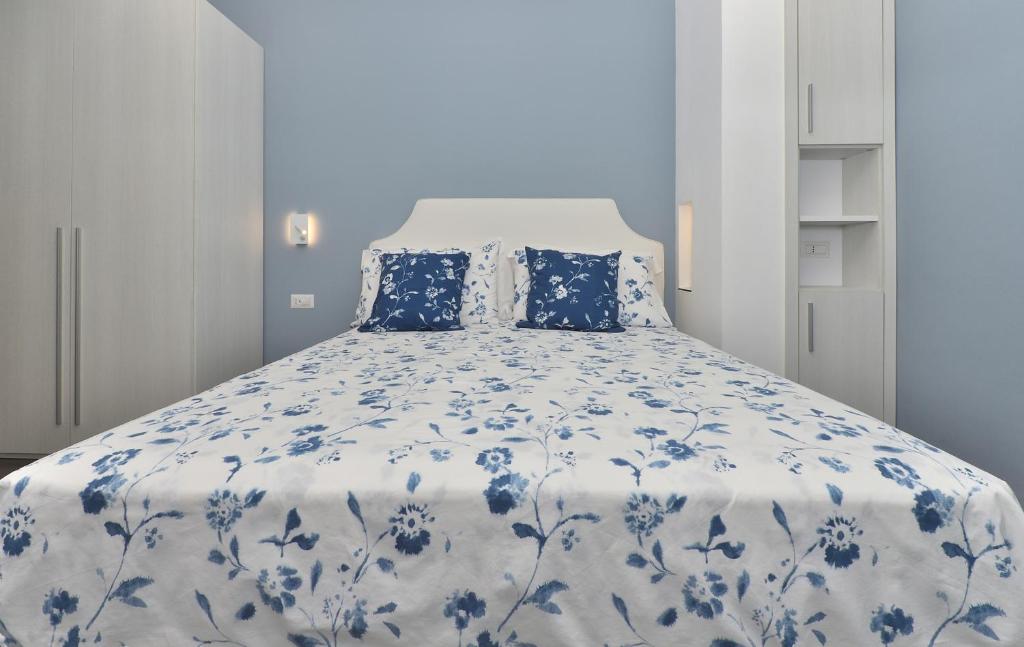 łóżko z niebiesko-białym kocem i poduszkami w obiekcie Costa d'Amalfi Apartments w mieście Minori