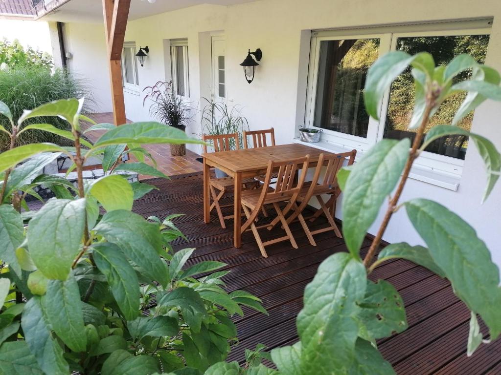 eine Terrasse mit einem Holztisch und Stühlen auf einem Haus in der Unterkunft Apartment Kieselsgrund in Dielheim