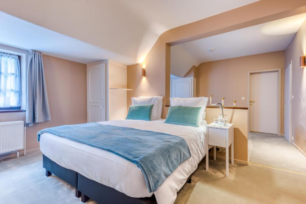 sypialnia z dużym łóżkiem i stołem w obiekcie Hôtel Imperi'Ale w mieście Comblain-la-Tour