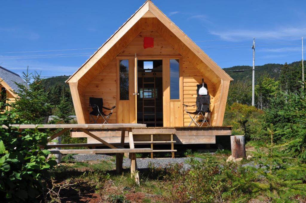 een tiny house met een veranda en een tafel bij The ZzzzMoose in Birch Plain