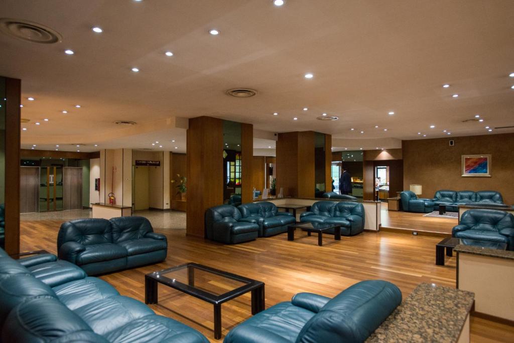 a waiting room with leather couches and a table at Hotel San Francesco in Rende