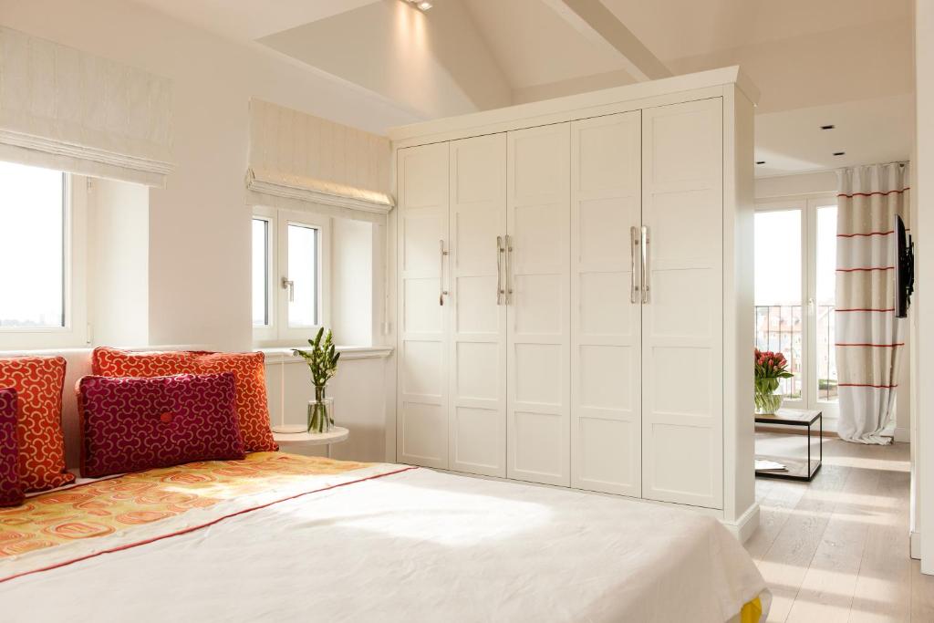 a bedroom with a bed and a large white cabinet at Hotel Sylter Zollhaus in Westerland