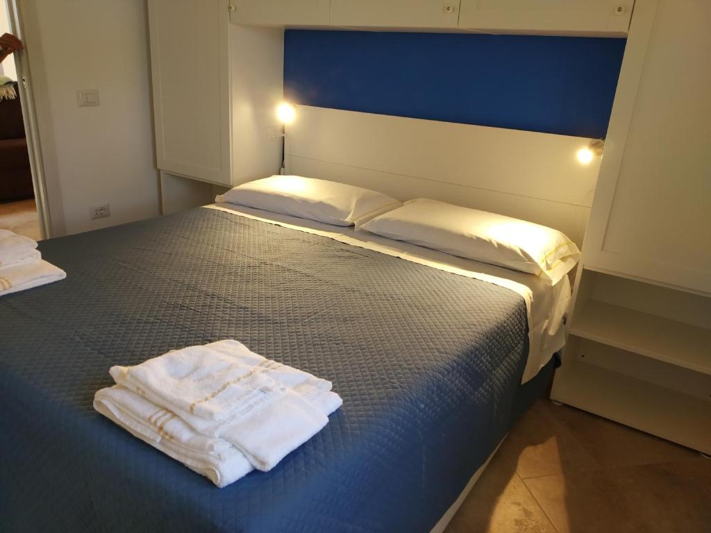 Un dormitorio con una cama con toallas blancas. en Villa "Maritima" en SantʼAndrea