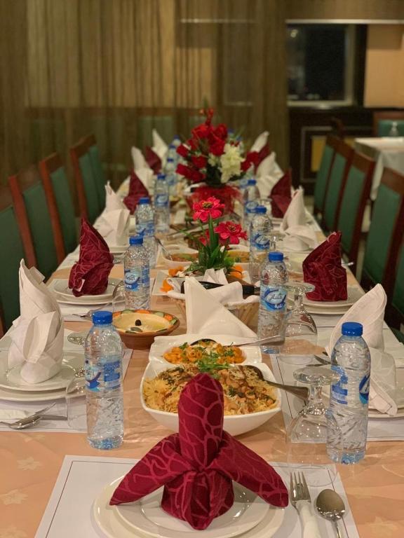a long table with plates of food and water bottles at Hala Inn Hotel Apartments - BAITHANS in Ajman 