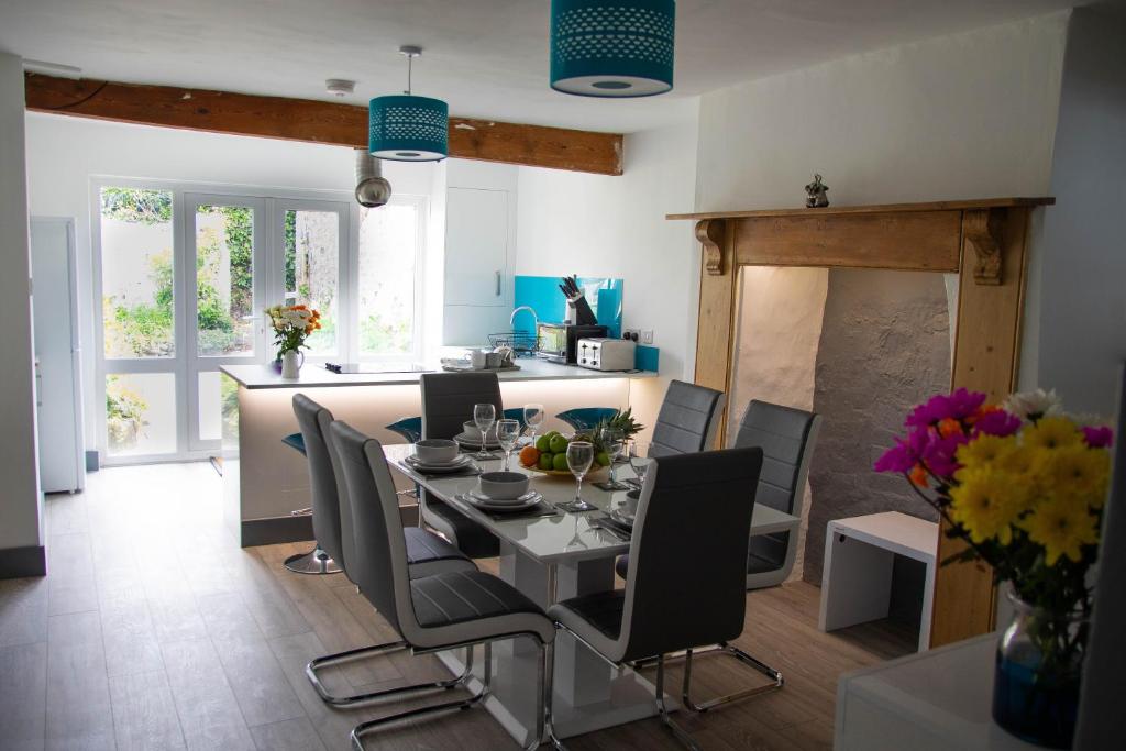 een eetkamer en een keuken met een tafel en stoelen bij Westeria Cottage in Barnstaple