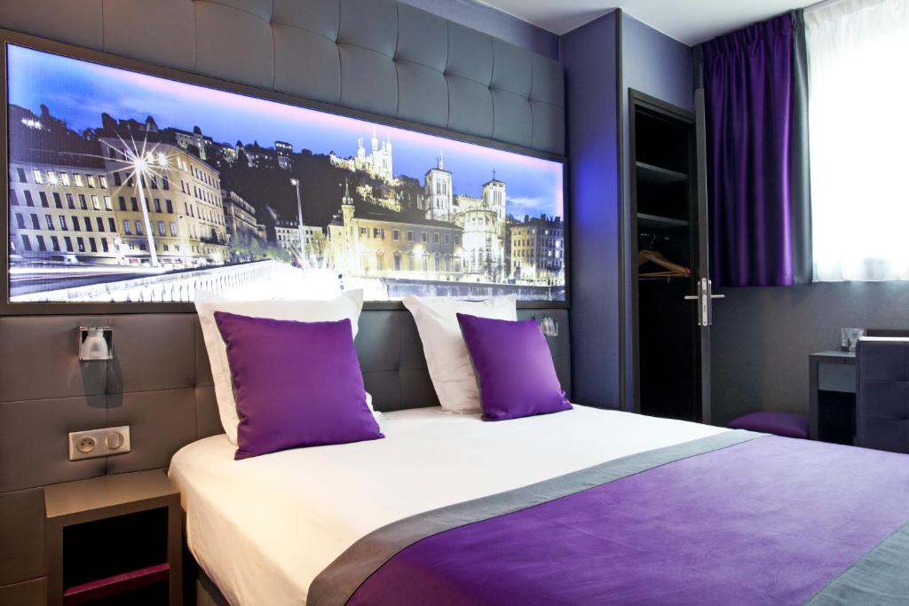 a bedroom with a large picture of a city at Hotel des Savoies Lyon Perrache in Lyon