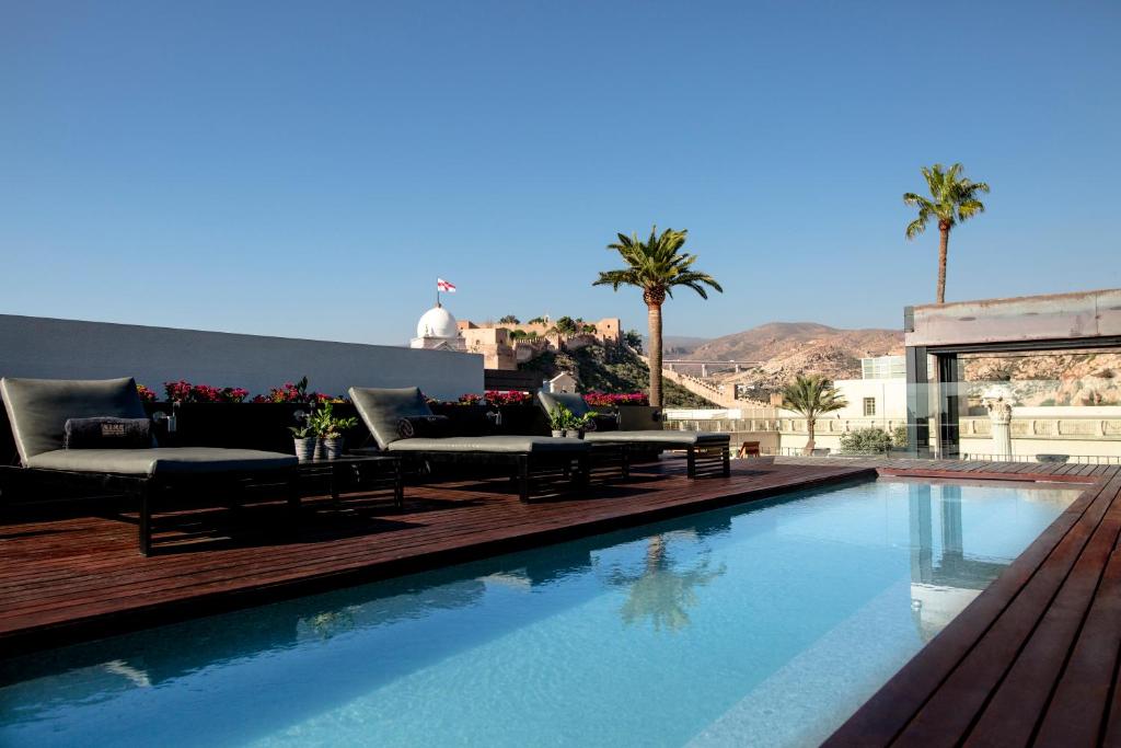a swimming pool with two couches and a pool at Aire Hotel & Ancient Baths in Almería