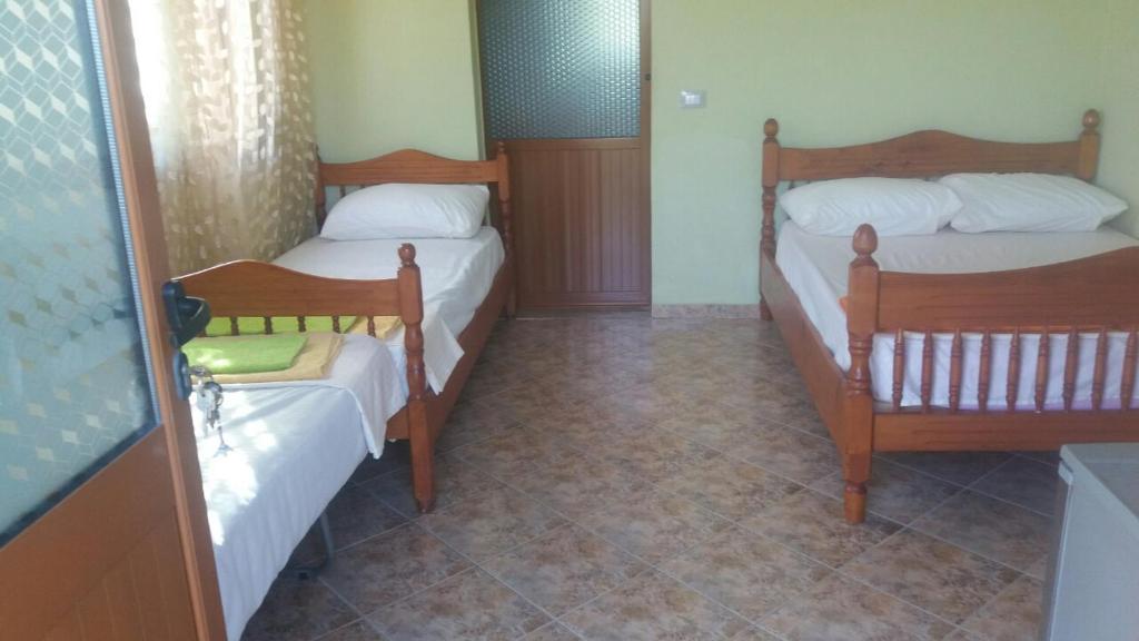 2 Betten in einem kleinen Zimmer mit in der Unterkunft Mullaj Guest House in Vlorë