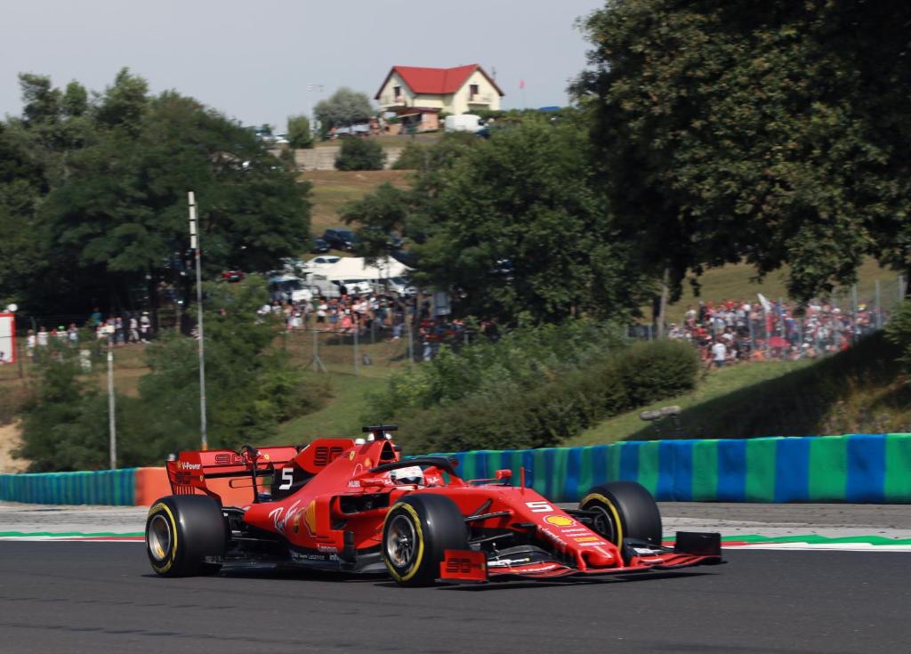 un coche de carreras rojo conduciendo por una pista de carreras en Kamarás Ring House en Mogyoród