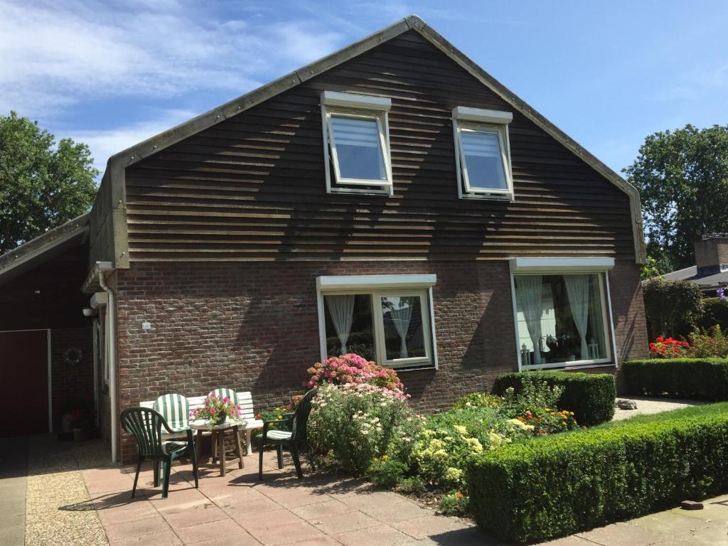 een huis met een tafel en stoelen ervoor bij de Duinroos in Oostkapelle