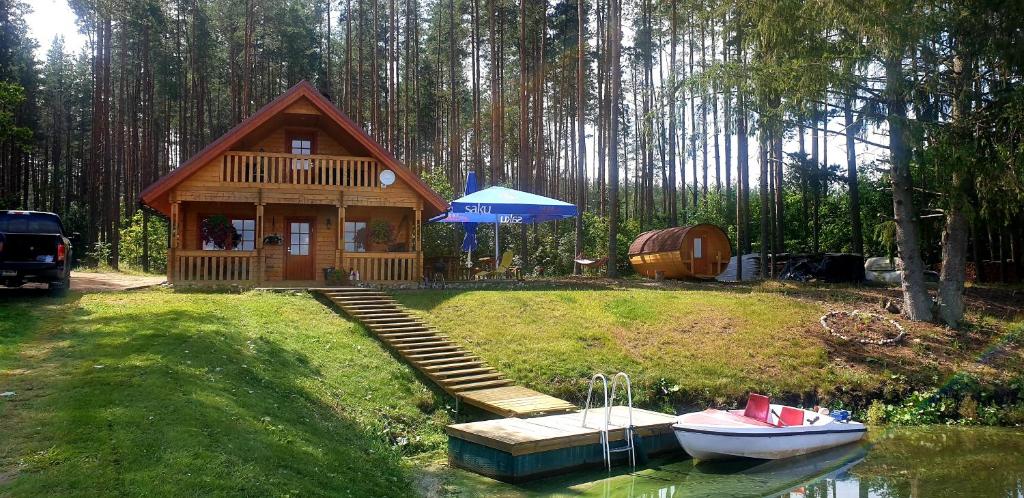 a small cabin with a boat in the water at Juba Holiday House in Võru