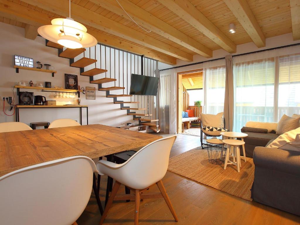 a dining room and living room with a table and chairs at Apartments Maison in Kranjska Gora