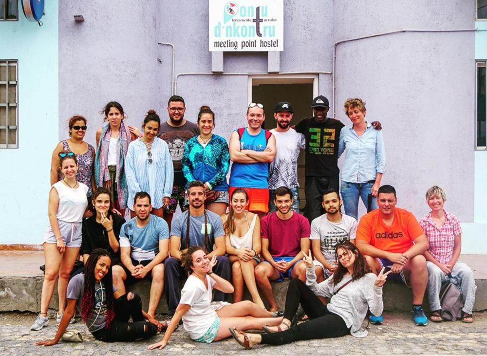 een groep mensen die poseren voor een foto voor een gebouw bij Tarrafal's Meeting Point in Tarrafal