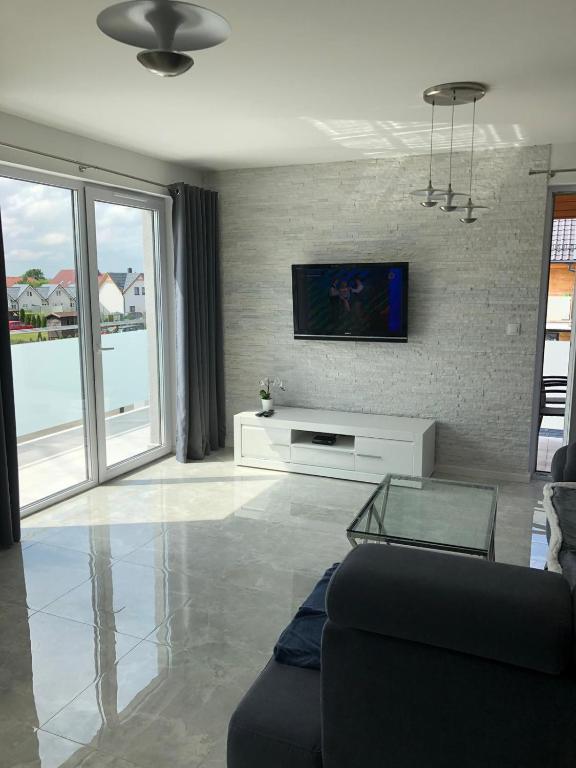 a living room with a couch and a tv on a wall at sandra1 in Jantar