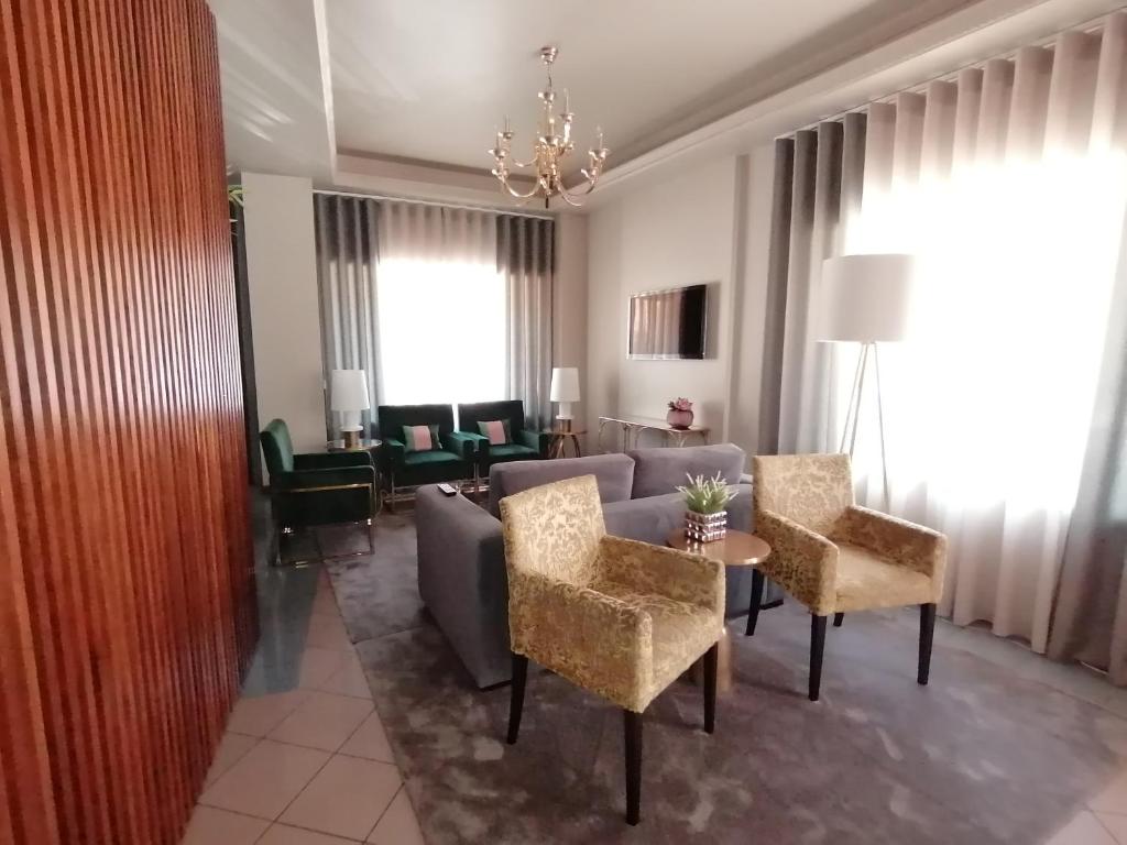 sala de estar con sofá, mesa y sillas en Residencial Imperial, en Luso