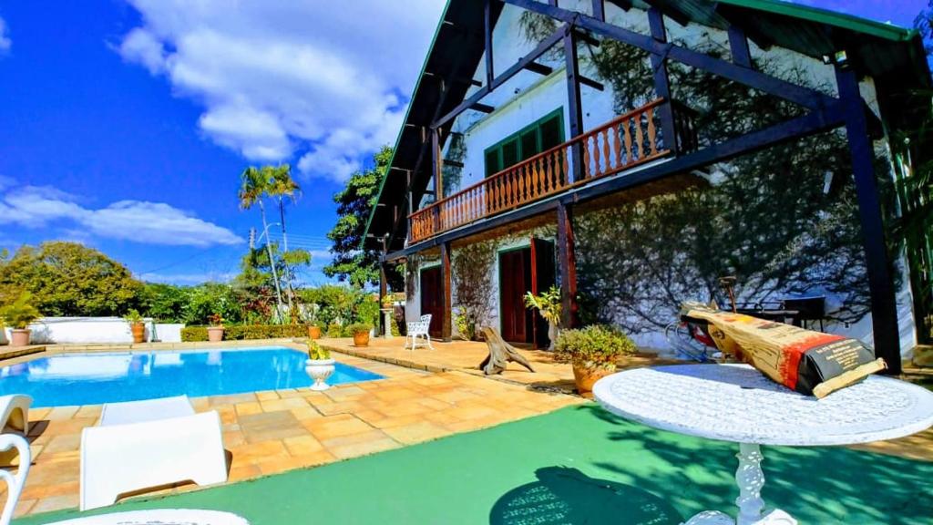 ein Haus mit einem Pool und einer Terrasse in der Unterkunft Paraiso dentro da cidade in Serra Negra