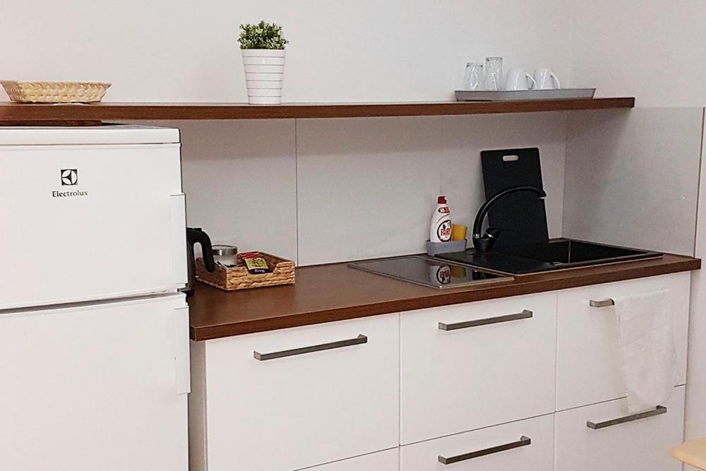 a kitchen with a white refrigerator and a sink at Apartamenty Wałowa 7a - ap. Kompaktowy in Łańcut