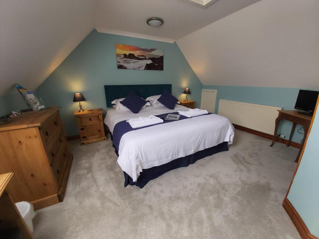 a bedroom with a large bed with blue walls at Chynoweth Trelash B&B in Trelash