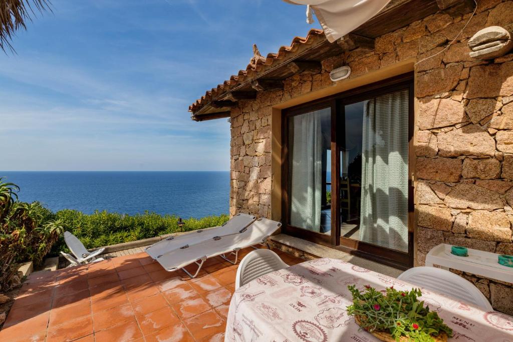 uma casa de pedra com vista para o oceano em Villa La Macchia em Costa Paradiso