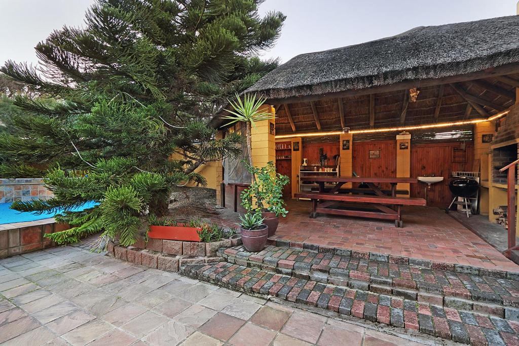 a house with a patio and a table in front of it at Natalie Guesthouse in Bloubergstrand
