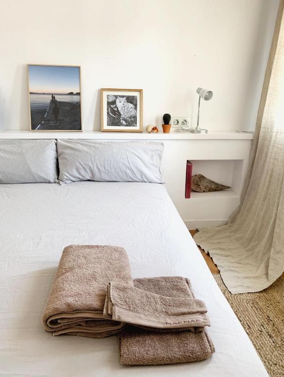 Un dormitorio con una cama blanca con toallas. en Apartment Boutique Hort, en Cadaqués