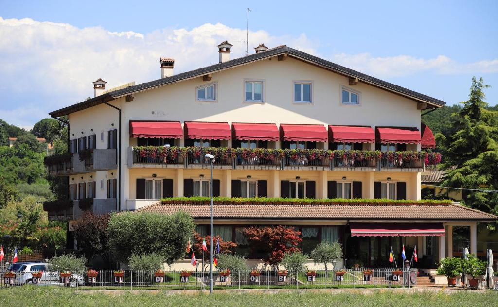 a large building with red awnings on it at Hotel da Roberto in Lazise