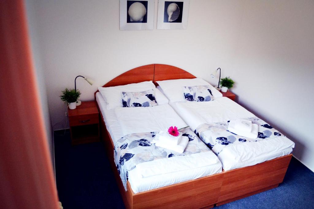 um quarto com uma cama com lençóis brancos e flores em Hotel S-centrum em Benešov